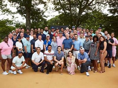 A large group of individuals smiles to the camera.