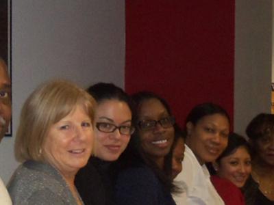 A group of diverse adults smile toward the camera