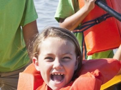 children smiling on a kayak