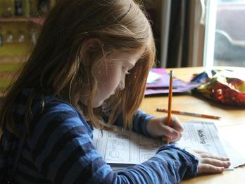 A child writing at a desk.